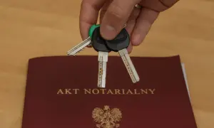 Klucze do nowego domu leżą na akcie notarialnym, który potwierdza akt własności.