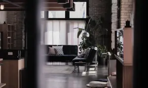 Nowoczesne wnętrze z czarną kanapą, designerskimi lampami i roślinami. To przykład, co to są ruchomości w aranżacji wnętrz.