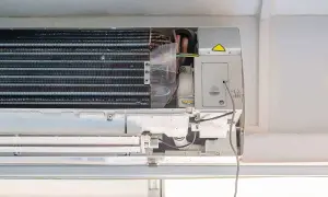 Wnętrze klimatyzacji w mieszkaniu, widoczne żeberka chłodzące i przewody.