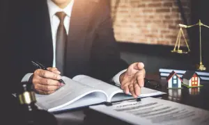 Prawnik analizuje dokumenty, zastanawiając się, czy komornik może zająć mieszkanie, którego jestem współwłaścicielem.