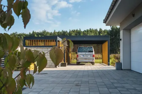 Nowoczesna wiata samochodowa, idealna na działkę, gdzie nie potrzebujesz pozwolenia na budowę. Auto zaparkowane pod zadaszeniem.