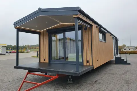 Nowoczesny domek holenderski z tarasem i oświetleniem LED. Jego wysokość jest optymalna dla mobilnego domu.