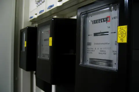 Trzy liczniki energii elektrycznej, jeden z nich pokazuje 310457.7 kWh. To może być podstawa do wyliczenia średniego rachunku za prąd w mieszkaniu.