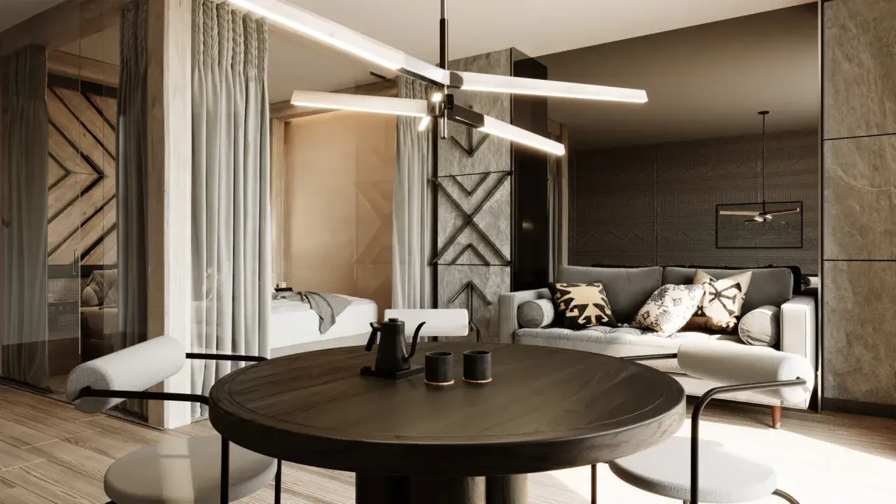 Nowoczesny apartament inwestycyjny z częścią sypialnianą oddzieloną zasłonami, salonem z szarą sofą i okrągłym stołem jadalnianym.