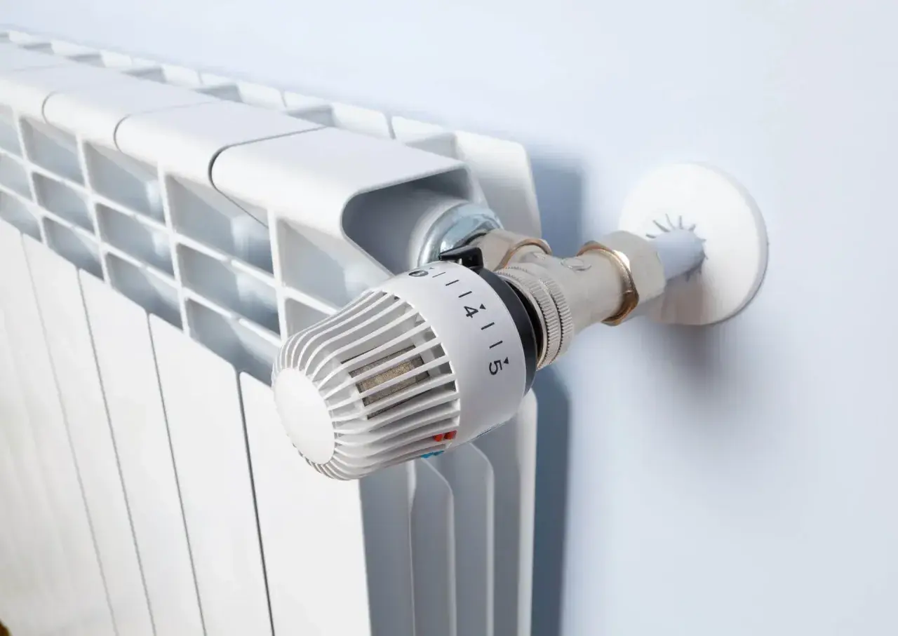 Biały grzejnik z termostatem. Idealne rozwiązanie, jeśli zastanawiasz się, jakie ogrzewanie do domu 70m2 wybrać.